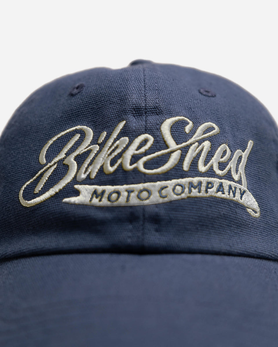 Navy blue cap script cap with 'Bike Shed Moto Company' logo on a white background