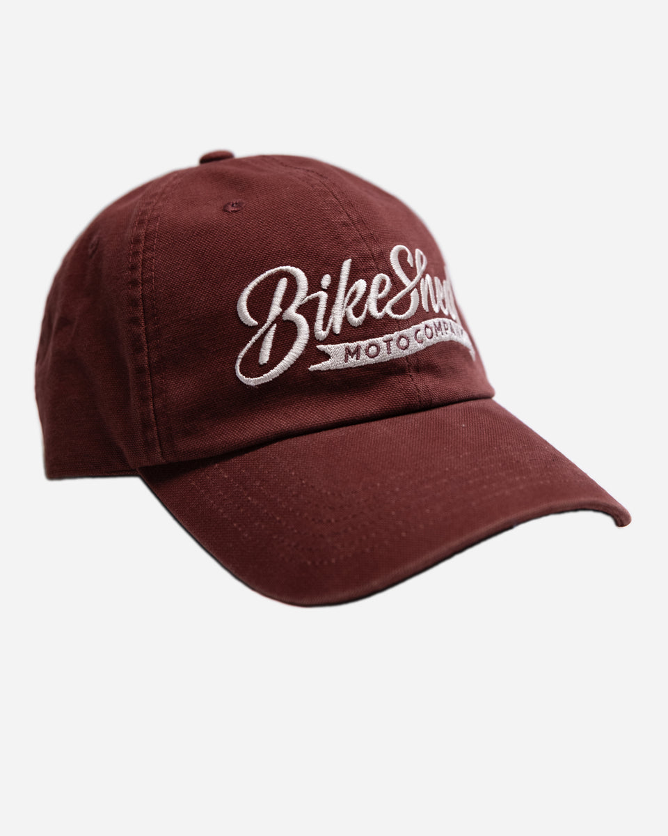 Red cap studio shot with 'Bike Shop Moto Company' logo on a white background