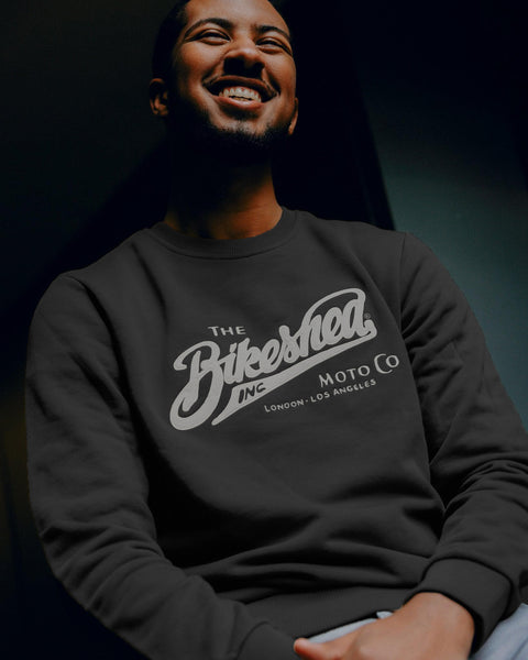 Person wearing a black sweatshirt with 'The Bikeshed Moto Co' logo on a dark background